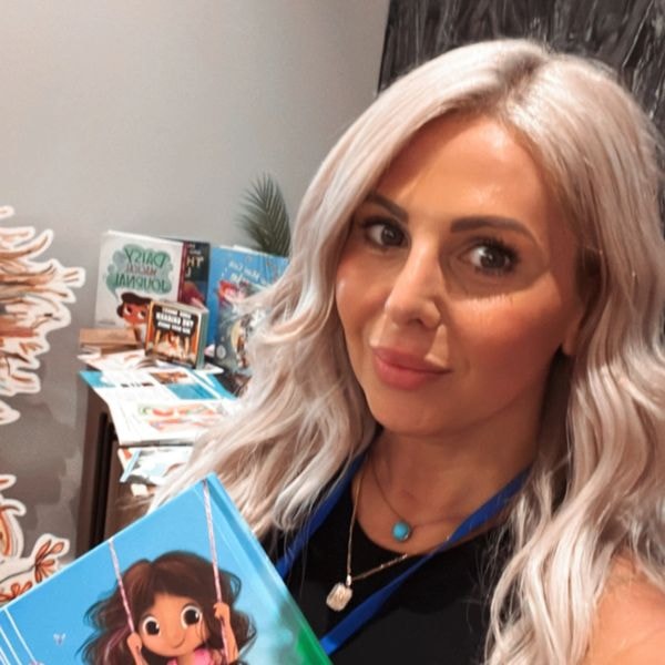 Melanie Garda, author of Mia's Blue Shoes, holding the book